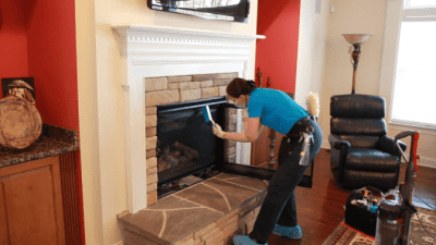 How to Clean a Gas Fireplace, Angela Brown Dusting Inside Around Glass With Brush